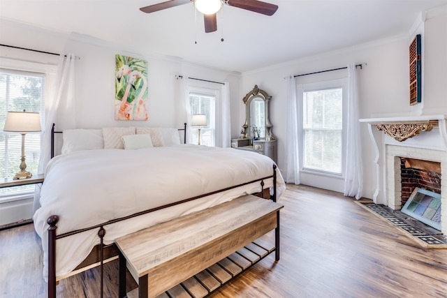 bedroom with multiple windows, ceiling fan, crown molding, and light hardwood / wood-style floors