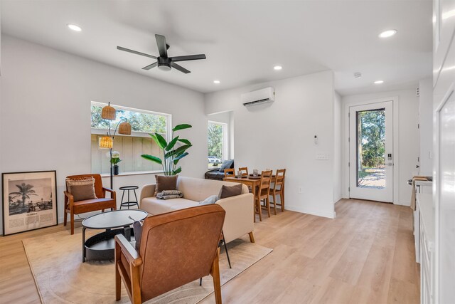 living room with light hardwood / wood-style floors, a wall unit AC, and ceiling fan