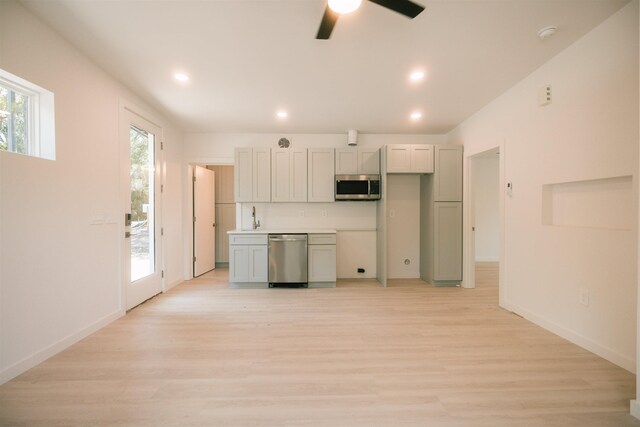 kitchen with stainless steel appliances, ceiling fan, light hardwood / wood-style floors, and sink