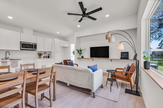 living room with ceiling fan and light hardwood / wood-style flooring