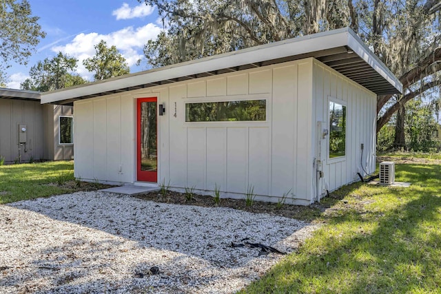 view of outbuilding featuring central air condition unit and a yard