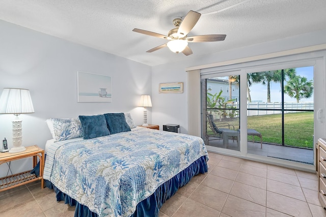 bedroom featuring access to outside, light tile patterned floors, a textured ceiling, and a ceiling fan