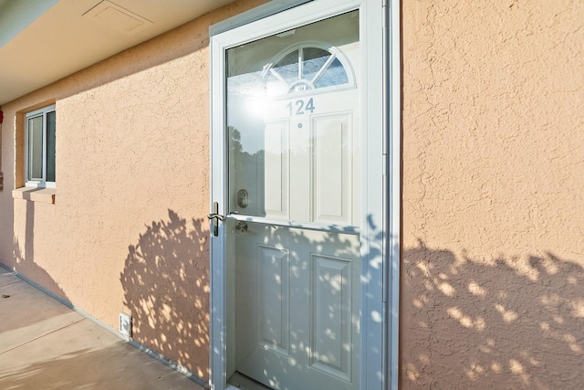 view of exterior entry featuring stucco siding