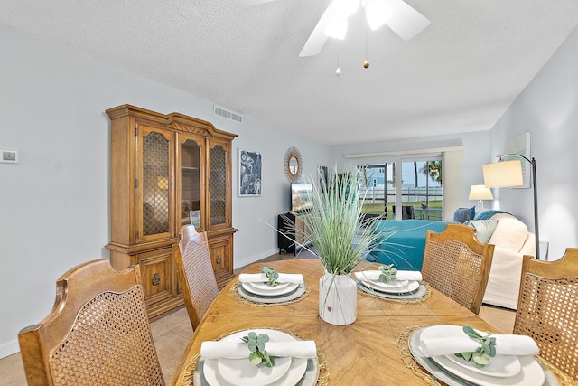 dining room featuring ceiling fan, baseboards, and a textured ceiling