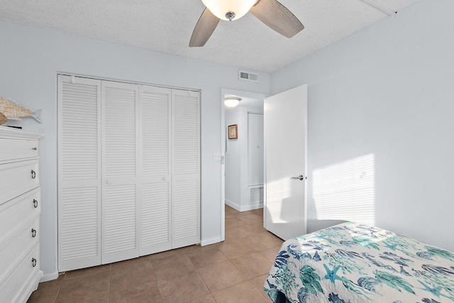 bedroom featuring tile patterned floors, a closet, ceiling fan, and baseboards