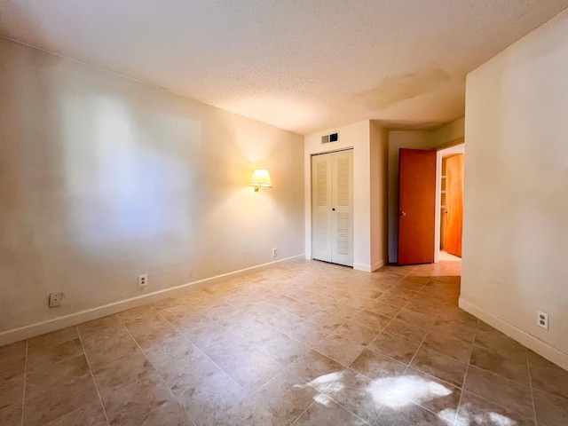 unfurnished room with a textured ceiling