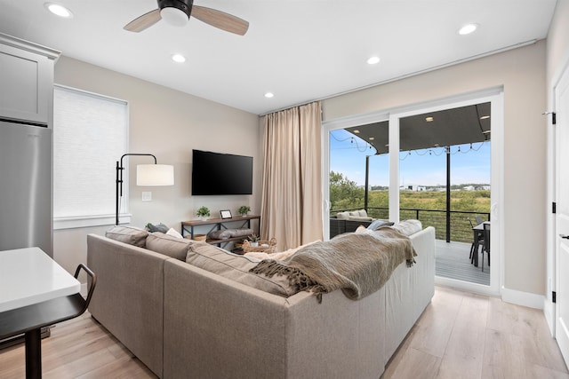 living room with light hardwood / wood-style floors and ceiling fan