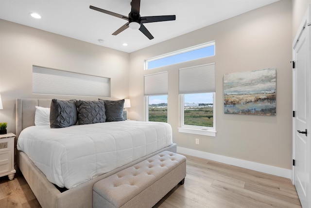 bedroom with light hardwood / wood-style floors and ceiling fan