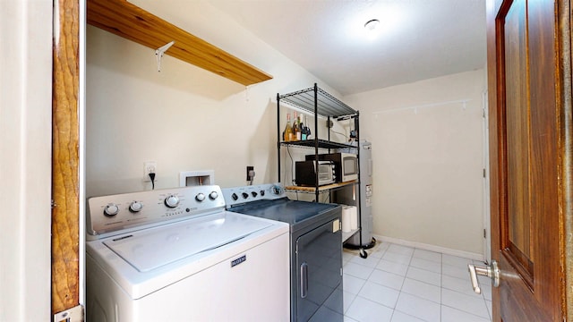 40 Sandpiper Dr, Saint Augustine, FL 32080 - washroom featuring washing machine and clothes dryer, light tile patterned floors, and baseboards