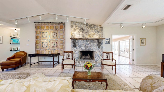 40 Sandpiper Dr, Saint Augustine, FL 32080 - tiled living area with rail lighting, vaulted ceiling, a stone fireplace, and baseboards