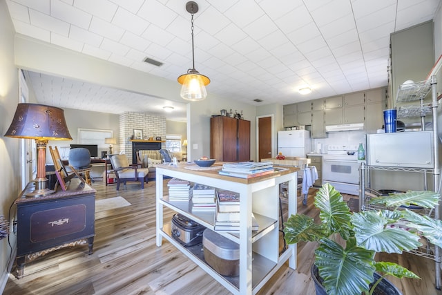 kitchen featuring pendant lighting, gray cabinetry, white appliances, and light hardwood / wood-style flooring