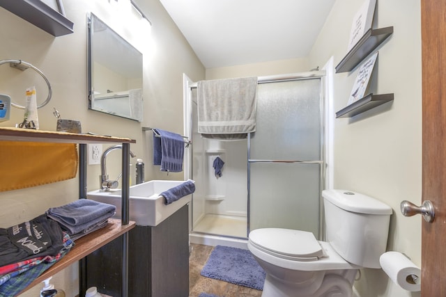 bathroom with toilet, a shower with door, and sink