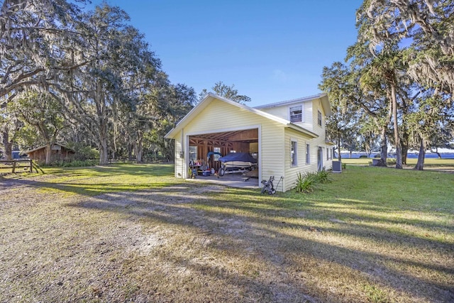 view of side of home with a garage, a yard, and an outbuilding