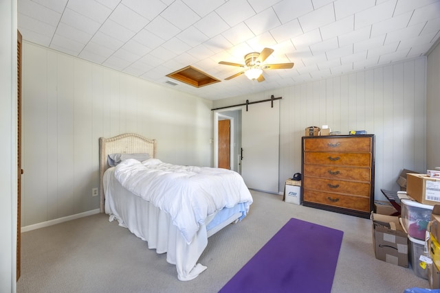 bedroom featuring ceiling fan, light carpet, and wooden walls