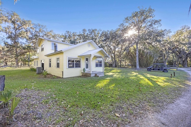 view of front of property featuring central air condition unit and a front yard