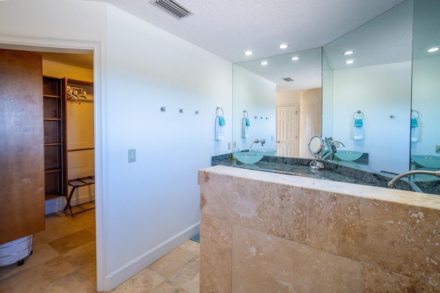 bathroom with vanity and a textured ceiling