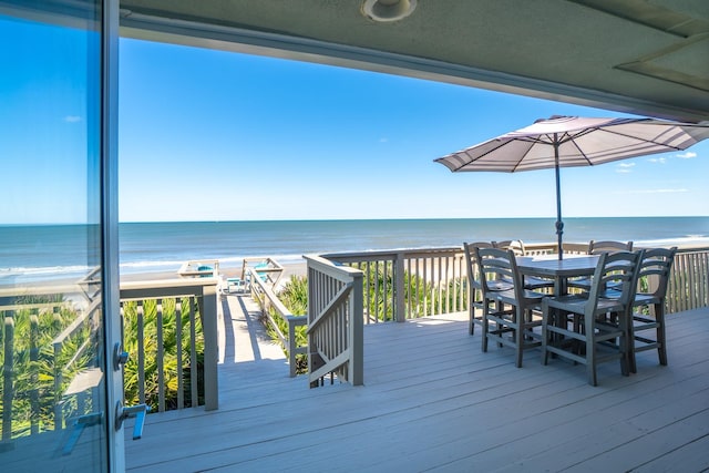 wooden deck with a water view and a beach view