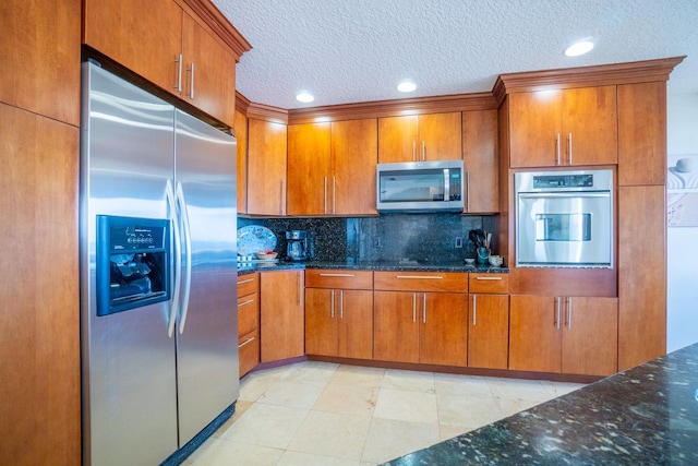 kitchen featuring light tile patterned floors, stainless steel appliances, tasteful backsplash, and dark stone countertops