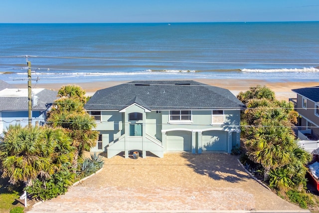 view of front of property with a view of the beach, a water view, and a garage