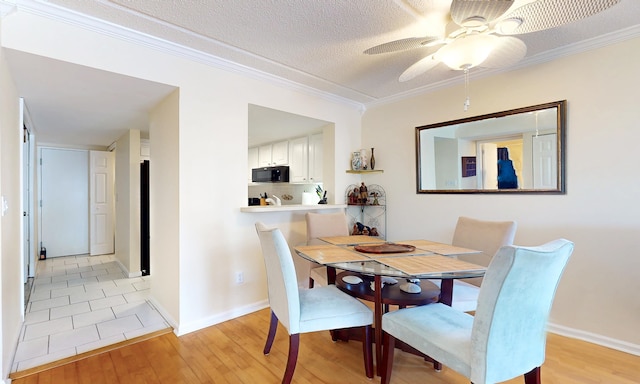  - dining area with light wood-style floors, ceiling fan, ornamental molding, and baseboards