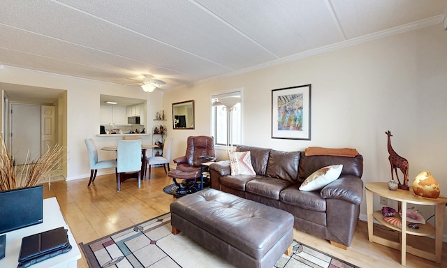  - living area featuring crown molding, light wood-style flooring, and a ceiling fan