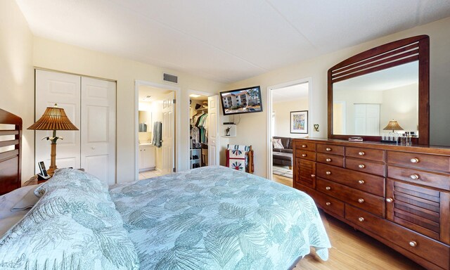  - bedroom with light wood-style flooring and ensuite bathroom
