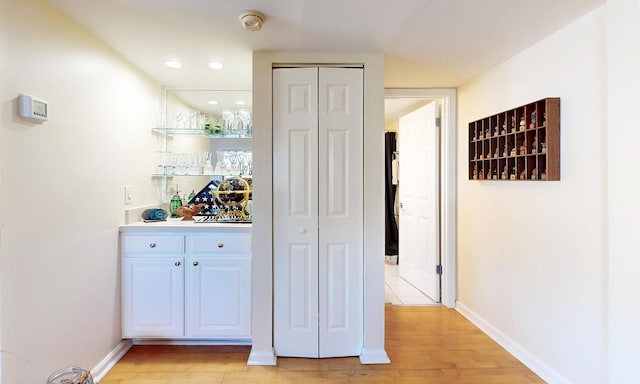  - indoor dry bar with light wood-style flooring, baseboards, and recessed lighting