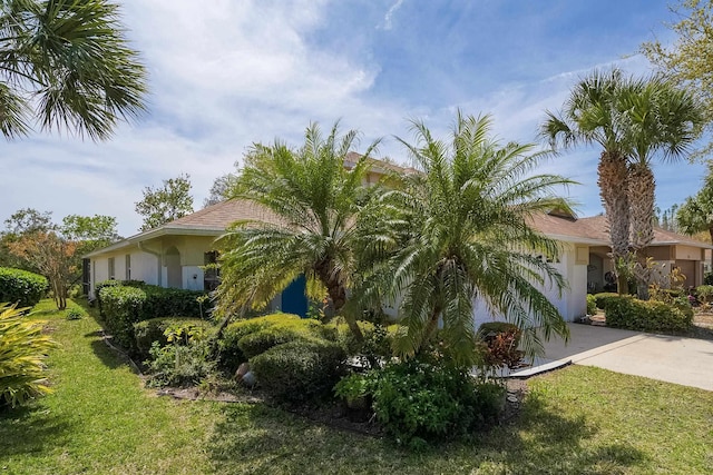 209 Lions Gate Dr, Saint Augustine, FL 32080 - view of side of property featuring concrete driveway, stucco siding, and a yard