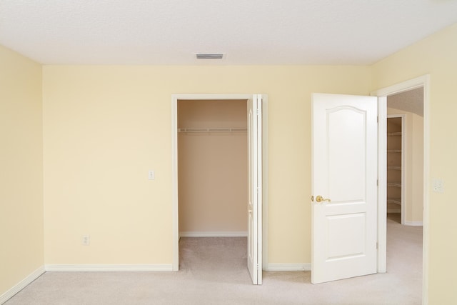 209 Lions Gate Dr, Saint Augustine, FL 32080 - unfurnished bedroom with a closet, light carpet, baseboards, and a walk in closet