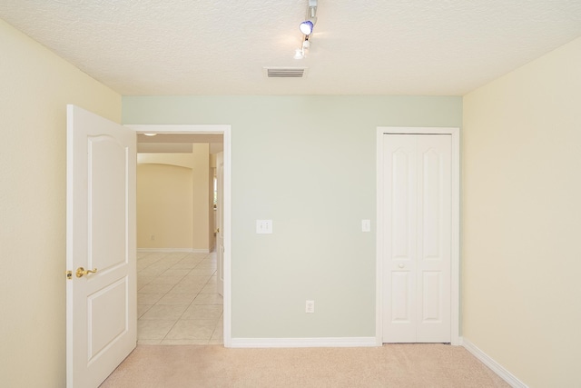 209 Lions Gate Dr, Saint Augustine, FL 32080 - unfurnished bedroom featuring light colored carpet, visible vents, baseboards, and a textured ceiling