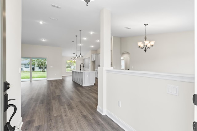 foyer with visible vents, baseboards, a notable chandelier, and dark wood-style flooring