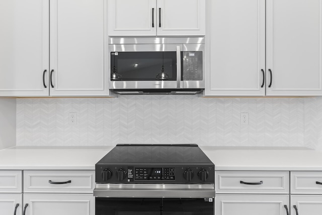 kitchen with stainless steel microwave, decorative backsplash, light countertops, and electric stove