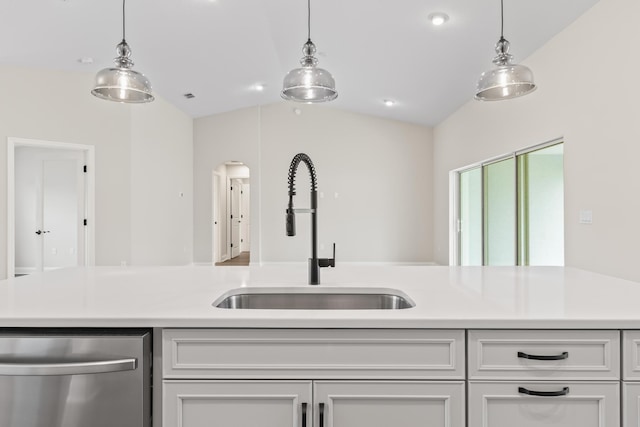 kitchen with pendant lighting, a sink, stainless steel dishwasher, light countertops, and lofted ceiling