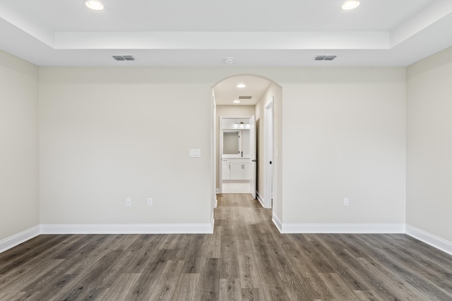 empty room with visible vents, baseboards, and wood finished floors