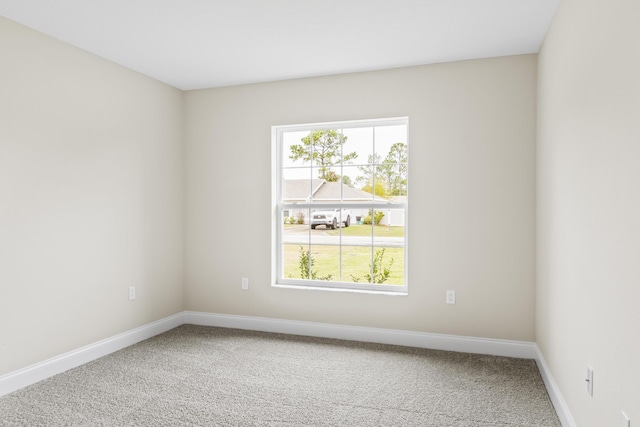 empty room featuring baseboards and carpet