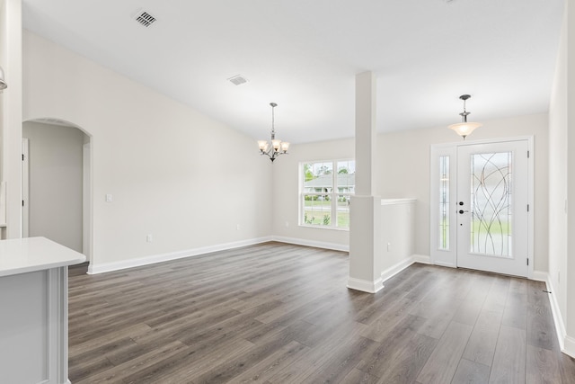 entrance foyer with visible vents, dark wood-type flooring, baseboards, a chandelier, and arched walkways