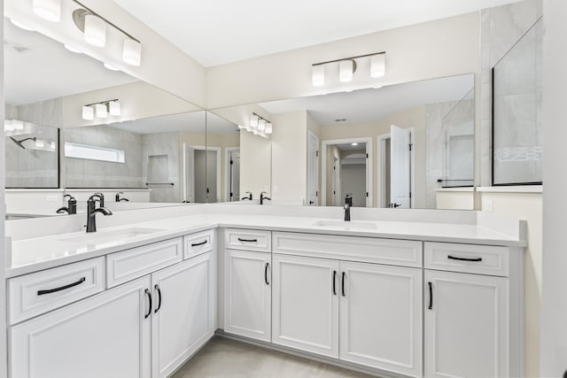 full bathroom featuring double vanity, visible vents, a walk in shower, and a sink