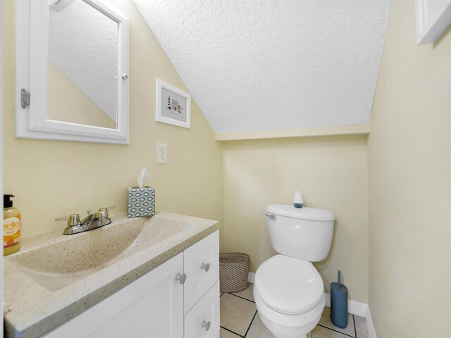 10 Seminole Dr, Saint Augustine, FL 32084 - bathroom featuring vanity, toilet, vaulted ceiling, a textured ceiling, and tile patterned flooring