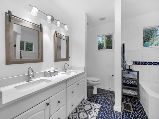10 Seminole Dr, Saint Augustine, FL 32084 - bathroom with double vanity, healthy amount of natural light, toilet, and tiled bath
