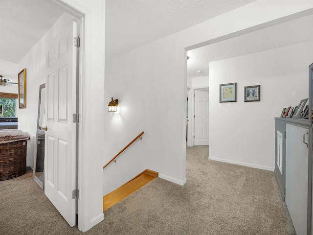 10 Seminole Dr, Saint Augustine, FL 32084 - hall featuring an upstairs landing, carpet floors, baseboards, and a textured ceiling