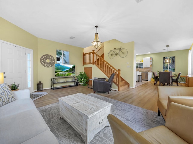 10 Seminole Dr, Saint Augustine, FL 32084 - living area featuring stairs, light wood-type flooring, baseboards, and a chandelier