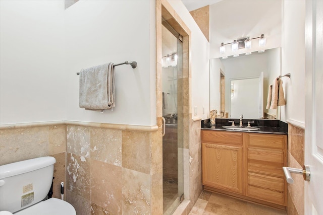 136 Lawn Ave, Saint Augustine, FL 32084 - bathroom featuring tile walls, a stall shower, vanity, and a wainscoted wall