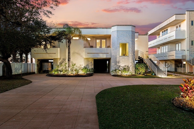 136 Lawn Ave, Saint Augustine, FL 32084 - view of front of home featuring stucco siding, curved driveway, and a balcony