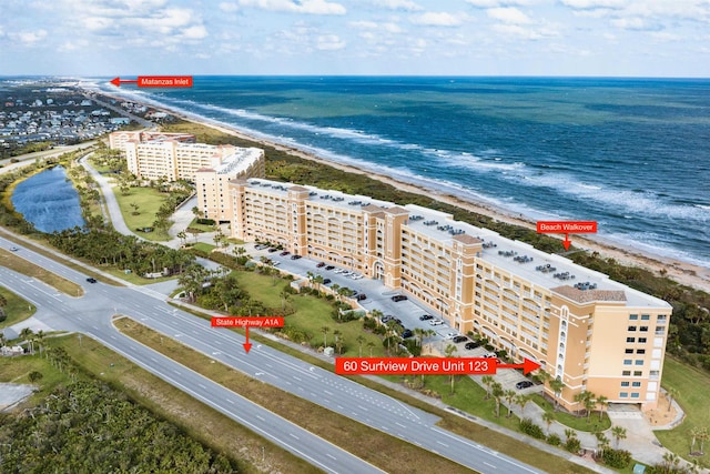 birds eye view of property with a water view and a view of the beach