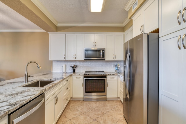 kitchen with stainless steel appliances, kitchen peninsula, light stone countertops, light tile patterned floors, and sink