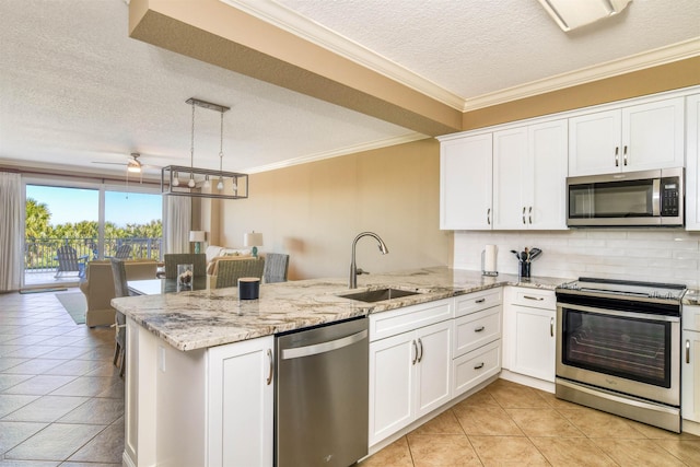 kitchen featuring stainless steel appliances, sink, a textured ceiling, kitchen peninsula, and pendant lighting