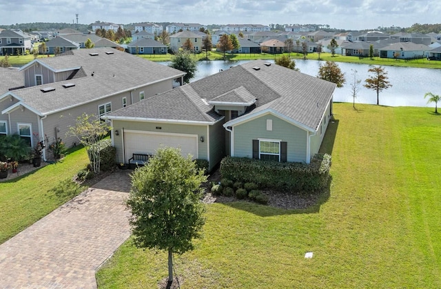 view of front facade featuring a garage, a residential view, a water view, decorative driveway, and a front yard