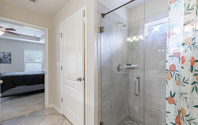 bathroom featuring a shower with shower curtain, tile patterned flooring, a healthy amount of sunlight, and a textured ceiling