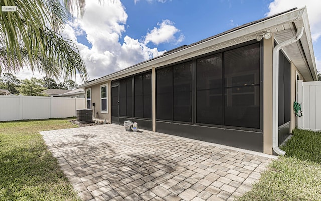 back of property with central AC, a sunroom, a yard, and a patio