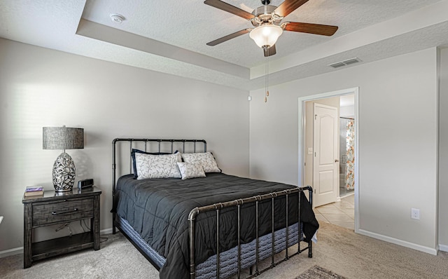 carpeted bedroom with ceiling fan and a textured ceiling